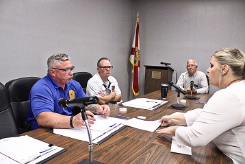 City Manager Laura Cain hands Chiefland Police Chief Scott Anderson a ballot to examine as fellow board members, Fire Chief James Harris, and County Coordinator Wilbur Dean, wait to see the document. Deliberations were just beginning.