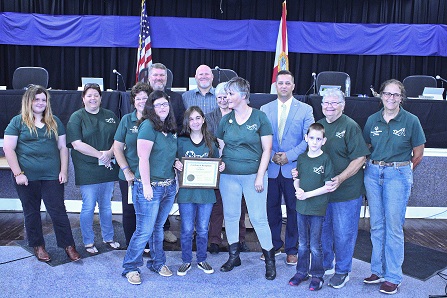 Lexi McCue receives a plaque from Levy County Commissioners honoring her three gold medals at the USA Special Olympics.