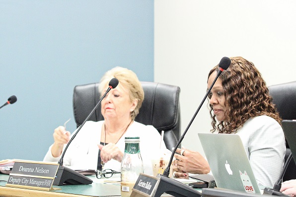 City Manager Jackie Gorman on the left and Deputy City Manager Deanna Nelson break from a pre-meeting huddle and pretend to be relaxed.