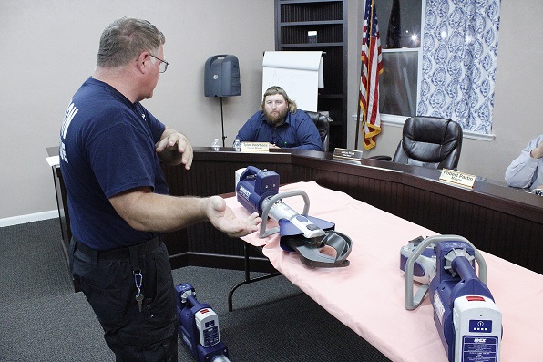 Assistant Chief Gail Foote shows off the three tools used in the operation of the Jaws of Life, the cutter, the spreader, and the ram at his feet. Councilman Tyler Voorhees watches in the background.