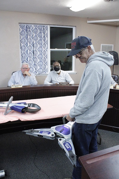 Lt. Bob Smith demonstrates the spreader tool as Mayor Robert Partin and Councilman Aaron Edmondson observe.