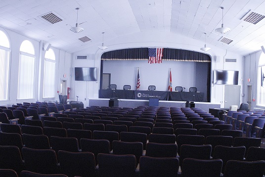 County commissioners use the former Bronson High School auditorium as their meeting room. The door of the little room where they met for a private lunch Tuesday is barely visible on the left side of the stage where they sat for two meetings.