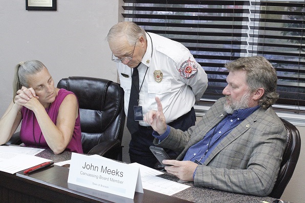 Canvassing Board members Bronson Deputy Clerk Wendy Maragh, Fire Chief Dennis Russell and County Commissioner John Meeks complete a final review of the vote count. Not shown is Town Manager Susan Beaudet, a fourth member of the canvassing board.