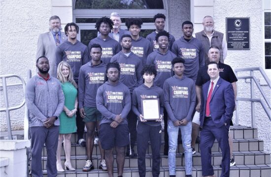 Levy County Commissioners pose with the 2023 State Champion Class 1A Williston High School basketball team. The team was honored at the board meeting. Shown from the left, first row, Assistant Coach Kori Lamb, County Commissioner Desiree Mills of Morriston, Kyree Edwards, Jaythian Merceds, Marcus Appling and County Commission Chairman Matt Brooks of Williston; second row Reggie White, Quincey Parker, Greg Maxwell, and Coach Jim Irvin; third row Jackson Islam, Javon Brown, Kyler Lamb, Deandre Harvey, and Corey Jelks. Back row, County Commissioners John Meeks, Tim Hodge, and Rock Meeks.