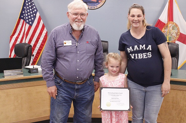 Mayor Charles Goodman presents the Student of the Month Award to Oaklee-Rae Parks as her mother Kayla watches.