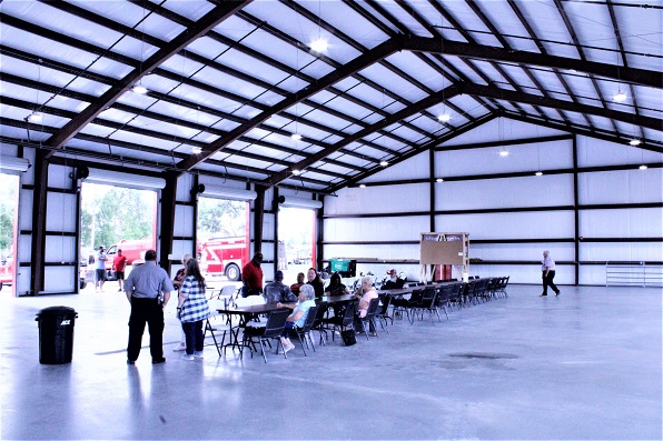 The fire bay looks cavernous as a small crowd of people gather at tables waiting for the start of the dedication. The fire bay doesn't just look big. It is big.