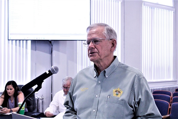 Sheriff Bobby McCallum got more than he bargained for at Tuesday's Levy County Commission budget hearing. He walked away smiling. Pictured behind him on the left are Procurement Coordinator Alicia Tretheway and County Coordinator Wilbur Dean.