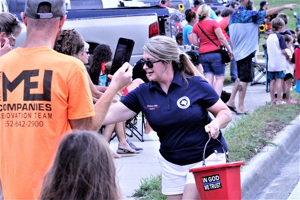 Levy County Commissioner Desiree Mills hands out candy to children along the parade route.