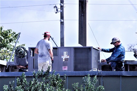 Technicians from Karlton’s Heating and Air work to install an air conditioning unit on the roof of the Levy County Development Department Thursday.