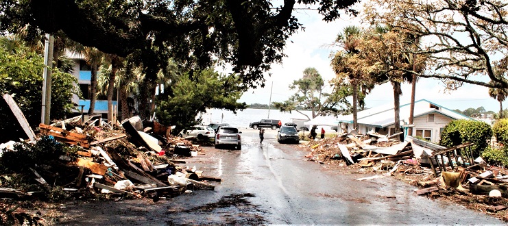 Storm debris is stacked on both sides of Third Street in Cedar Key. The Faraway Inn on the right side of the street sustained heavy damage from Idalia but still has a rental cottage available.