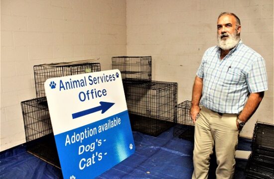 Animal Services Manager Rod Hastings shows off a new sign for the landfill entrance with an arrow pointing to the animal services office and a place at the bottom indicating the number of dogs and cats available for adoption.