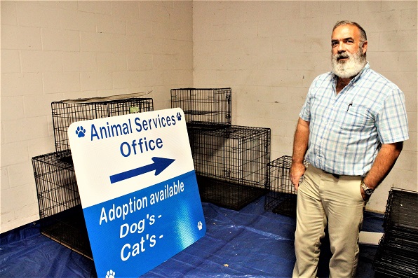 Animal Services Manager Rod Hastings shows off a new sign for the landfill entrance with an arrow pointing to the animal services office and a place at the bottom indicating the number of dogs and cats available for adoption.